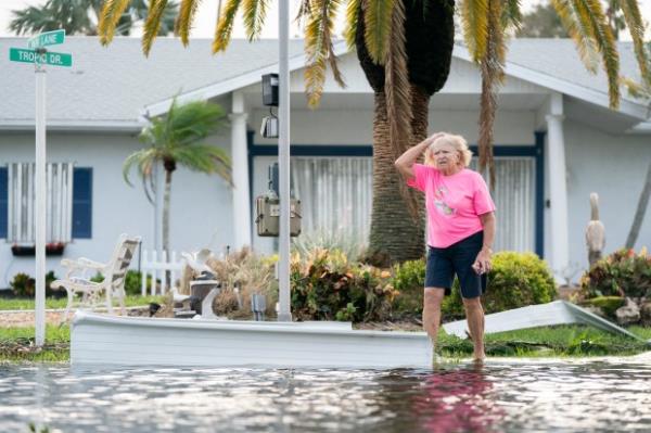 A woman walks along a flooded street in the aftermath of Hurricane Milton on October 10, 2024 in Osprey, Florida. (Photo by Sean Rayford/Getty Images)