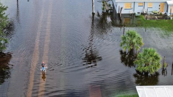 In this aerial view, a person walks through flood waters that inundated a neighborhood after Hurricane Milton came ashore on October 10, 2024, in Punta Gorda, Florida. (Photo by Joe Raedle/Getty Images)