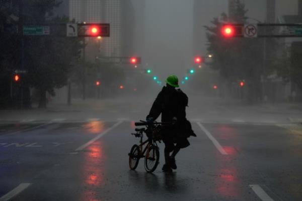 Ron Rook, who said he was looking for people in need of help or debris to clear, walks through windy and rainy co<em></em>nditions on a deserted street in downtown Tampa, Fla., during the approach of Hurricane Milton, Wednesday, Oct. 9, 2024. (AP Photo/Rebecca Blackwell)