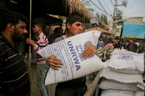 A man clutches a large sack of flour labeled UNRWA during distribution efforts in Deir al-Balah, Gaza, on Nov. 2, 2024. The Turkish Disaster and Emergency Management Presidency (AFAD) has provided flour amid a food crisis caused by o<em></em>ngoing Israeli attacks. 