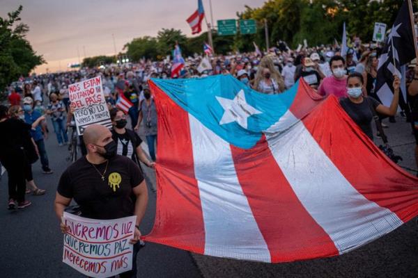 Protesters march along Las Americas Highway on Oct. 15, 2021, to demand the expulsion of power company LUMA amid a co<em></em>ntinued lack of electricity across the island.