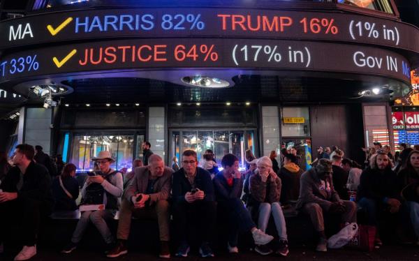 People watch election results trickle in at the Times Square Ticker Tape on election night in New York City, November 5, 2024. (Photo by David Dee Delgado / AFP)