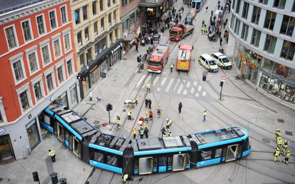 An overall view shows a derailed tram that has driven into a building in a busy street in the center of Oslo, Norway on October 29, 2024. - Approximately 20 people were on board the tram and emergency services have treated four injured people at the scene, none of them were seriously injured. (Photo by Terje Pedersen / NTB / AFP) / Norway OUT / NORWAY OUT