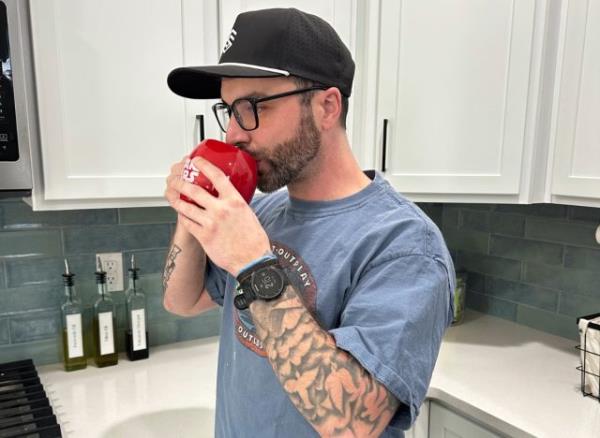 man drinking cup of black tea in his kitchen