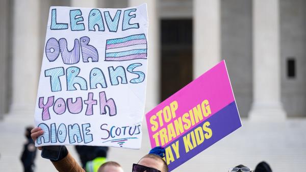 demo<em></em>nstrator with pro-trans signs outside Supreme Court