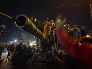 Syrians celebrate the arrival of opposition fighters in Damascus, Syria, Sunday ...