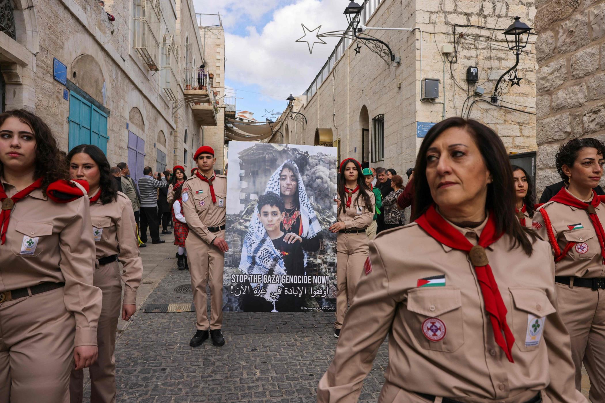 Palestinian scouts lift placards as they partake in the yearly Christmas procession toward the Church of the Nativity in Bethlehem town in the Israel-occupied West Bank, Palestine, Dec. 24, 2024. (AFP Photo)