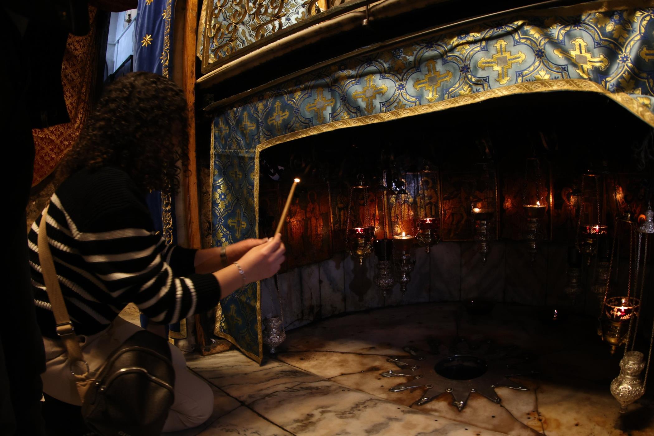 A visitor prays at the Grotto inside the Church of the Nativity ahead of Christmas, in the occupied West Bank city of Bethlehem, Palestine, Dec. 24, 2024. (EPA Photo)