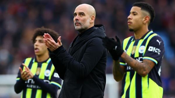 Pep Guardiola (C) applauds the travelling Manchester City fans