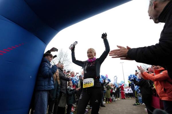 Belgian ultra runner Hilde Dosogne, center, is cheered on as she crosses the finish line during her 366th co<em></em>nsecutive marathon in Ghent, Belgium, Tuesday, Dec. 31, 2024. (AP Photo/Virginia Mayo)