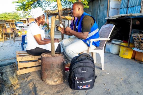 A community health worker provides counselling to a street cook in Bagamoyo before testing for HIV AIDS. Credit: Kizito Shigela/IPS